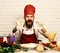 Chef kneads dough. Man with beard and hands in dough