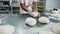 Chef kneads yeast dough on metal table in bakery slow motion