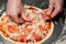 The chef lays out tomatoes while making pizza