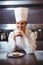 Chef leaning on the counter with a dish