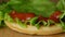 Chef makes a burger, pours ketchup on a fresh green leaf of lettuce close up view. Fast Food, Street Food close.