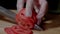 Chef making burger. Closeup mans hands cutting tomato for hamburger.