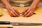 Chef making Omakase Menu: Saba Sushi Mackerel by his hand on wooden kitchen counter. Japanese luxury meal