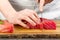 Chef making sashimi in kitchen, fresh raw tuna meat. seafood diet