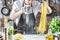 Chef making spaghetti noodles with pasta machine on kitchen table with some ingredients around