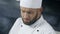 Chef man working at professional kitchen. Close up chef face cooking food