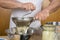 Chef mashing boiled potatoes to make gnocchi