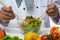 Chef mixes fresh vegetables in a plate