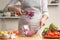 The chef mixes the salad, stir, in the process of a vegetarian salad in the home kitchen. Light background for restaurant menu