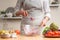 The chef mixes the salad, stir, in the process of a vegetarian salad in the home kitchen. Light background for restaurant menu