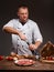 The chef opens a bottle of wine. Traditional spanish jamon, spices, tomatoes and onion rings