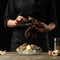 The chef opens and cleans the raw oyster against a background of white wine, lettuce, lemons and limes