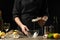 The chef opens and cleans the raw oyster against a background of white wine, lettuce, lemons and limes