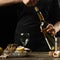 Chef opens Italian dry wine with oysters with lemon, on a dark background