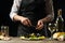 Chef opens a knife with mussels with a salad with white wine, on a dark background, the concept of the restaurant, menu and hotel