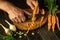 The chef peels carrots on a kitchen cutting board with a knife to prepare vegetable borscht. Vegetarian food concept for