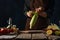 The chef peels the corn. He makes boiled corn with crayfish, vegetables and lemon. Wooden texture. Dark background. Hotel,