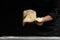 Chef pizza maker preparing pizza, holding rolled dough in hands. On a black background for design