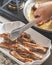 Chef places fried baby back ribs to a white dish