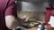 Chef plating up a burger on hot plate