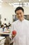 Chef portrait in school cafeteria holding apple