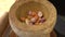 Chef pounding Spicy shrimp paste in a brown stone mortar.