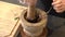 Chef pounding Spicy shrimp paste in a brown stone mortar.