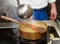 Chef is pouring broth in risotto