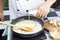 Chef pouring fresh milk the pan for cooking mushroom cream soup