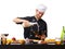 Chef pouring milk into a bowl on a table on a white isolated background