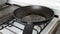 Chef pouring of olive oil onto frying pan on stove