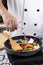 Chef pouring soup to the pan