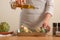 Chef pours olive oil and prepares to bake the artichoke on a light background, the concept of cooking tasty and healthy food, menu