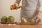 Chef pours olive oil and prepares to bake the artichoke on a light background, the concept of cooking tasty and healthy food, menu