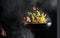 The chef prepares food in a hot pan with steam on a black background. The concept of restaurant and hotel service. Thai food pasta