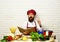 Chef prepares meal. Man with beard holds cook book