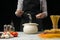 The chef prepares spaghetti and pasta, salt water, against a dark background, the concept of cooking