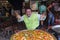 Chef prepares spanish seafood paella cooked in a large frying pan on street market restaurant , Bangkok, Thailand