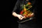 The chef prepares the vegetables on the pan. Black background for copying text. Restaurant business and advertising