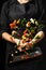 The chef prepares the vegetables on the pan. Black background for copying text. Restaurant business and advertising