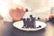 chef preparing dessert, putting blueberry on chocolate cake