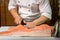 Chef preparing a fresh salmon fish on a cutting board, Japanese chef