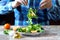 Chef preparing a healthy salad. Male hand mixed salad with mozzarella and tangerine.