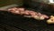 Chef preparing meat on grill.