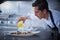 Chef preparing octopus in kitchen with smoke