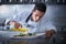 Chef preparing octopus in kitchen with smoke