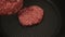 A chef puts beef patties on the grill. A juicy beef cutlet, fried in a pan. Close-up of a beef cutlet for a burger on the grill.