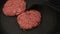 A chef puts beef patties on the grill. A juicy beef cutlet, fried in a pan. Close-up of a beef cutlet for a burger on the grill.