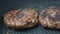 A chef puts beef patties on the grill. A juicy beef cutlet, fried in a pan. Close-up of beef cutlet for a burger on the grill