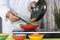 Chef puts fried vegetables into a bowl using chopsticks